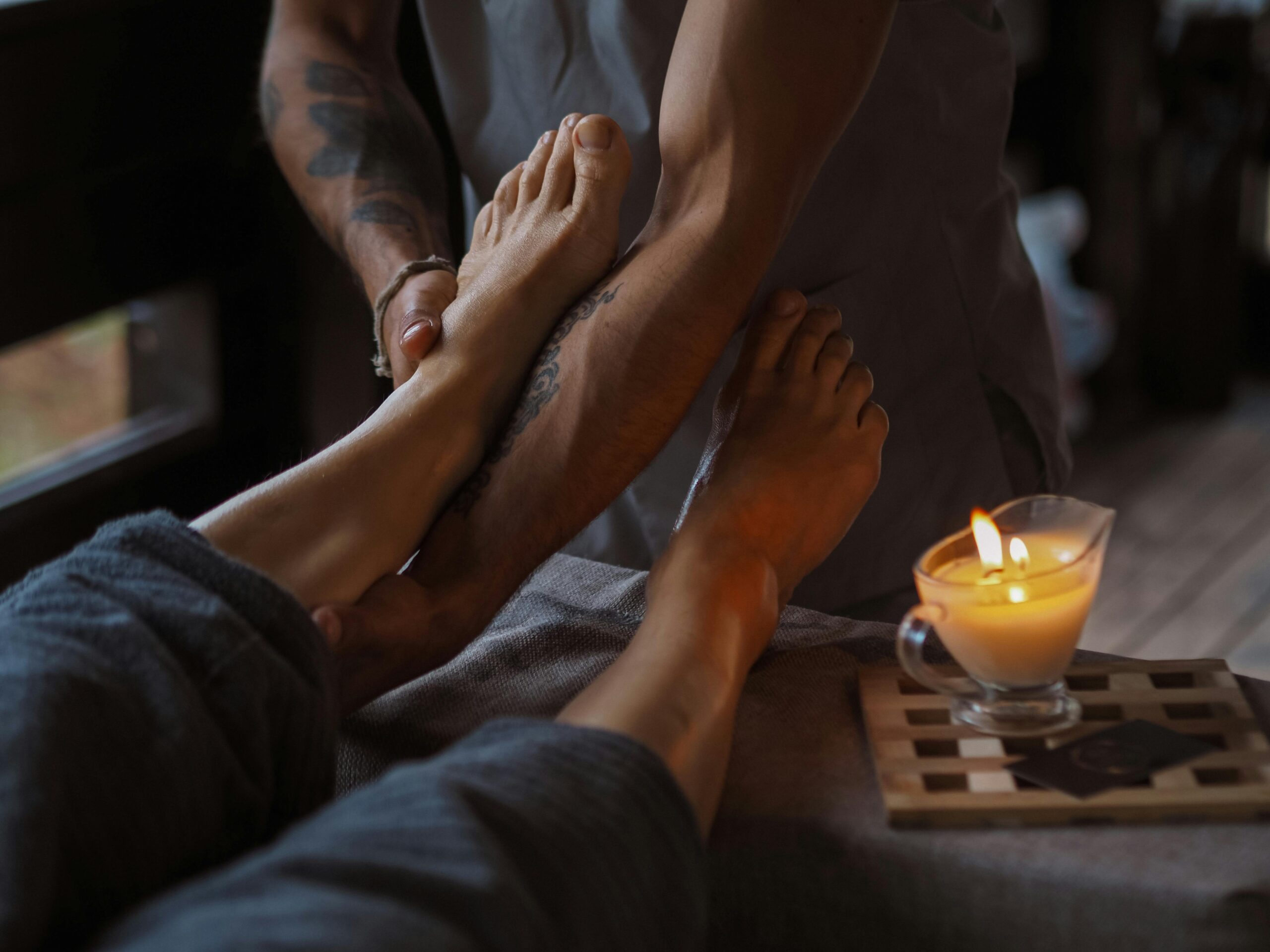Services A serene foot massage session lit by candlelight, ideal for relaxation and spa treatments.